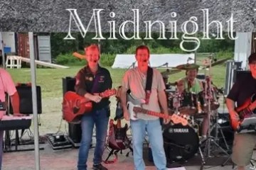 Band performing on outdoor stage with 'Midnight Rose' text above.